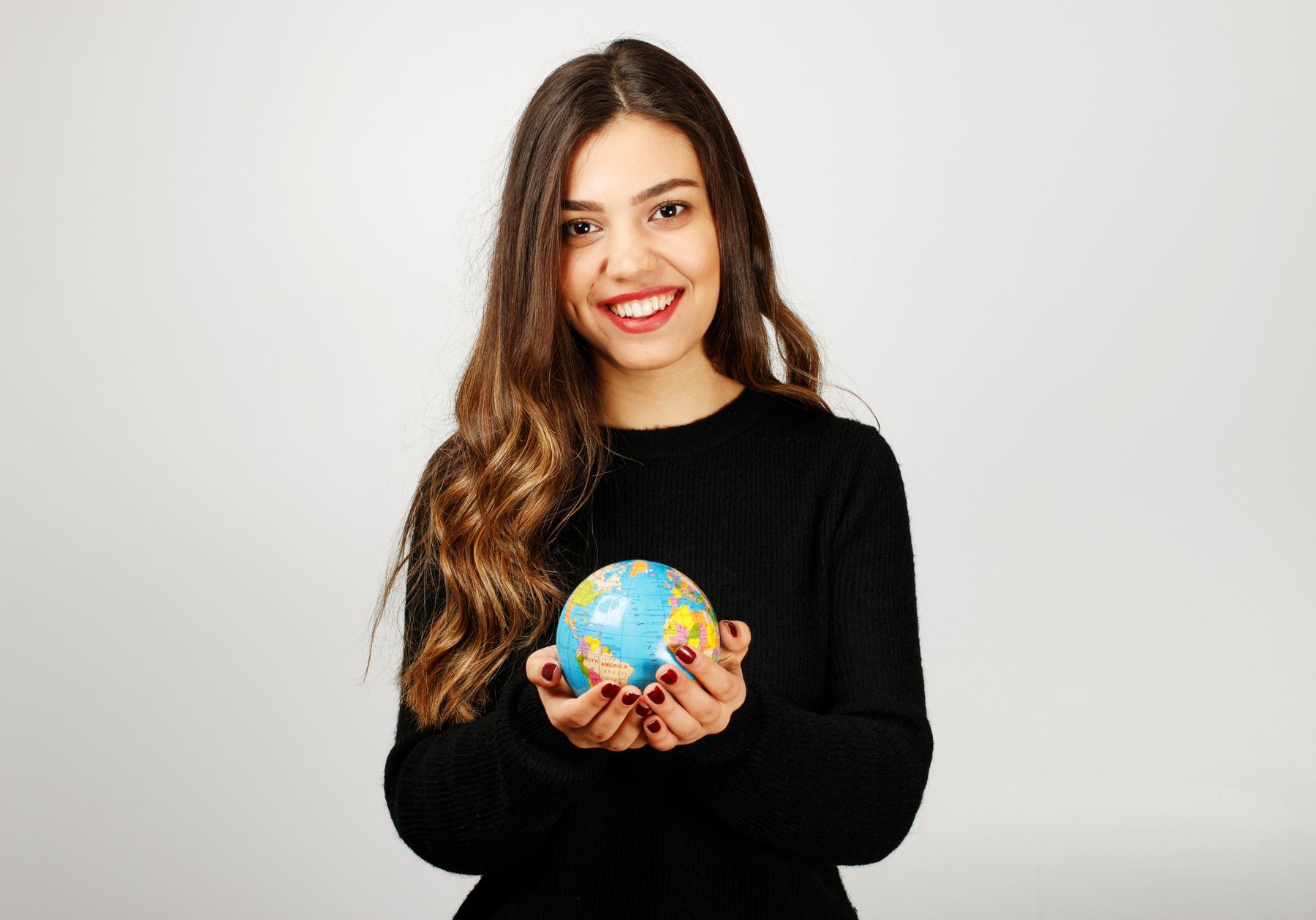 Joven sosteniendo un globo terráqueo